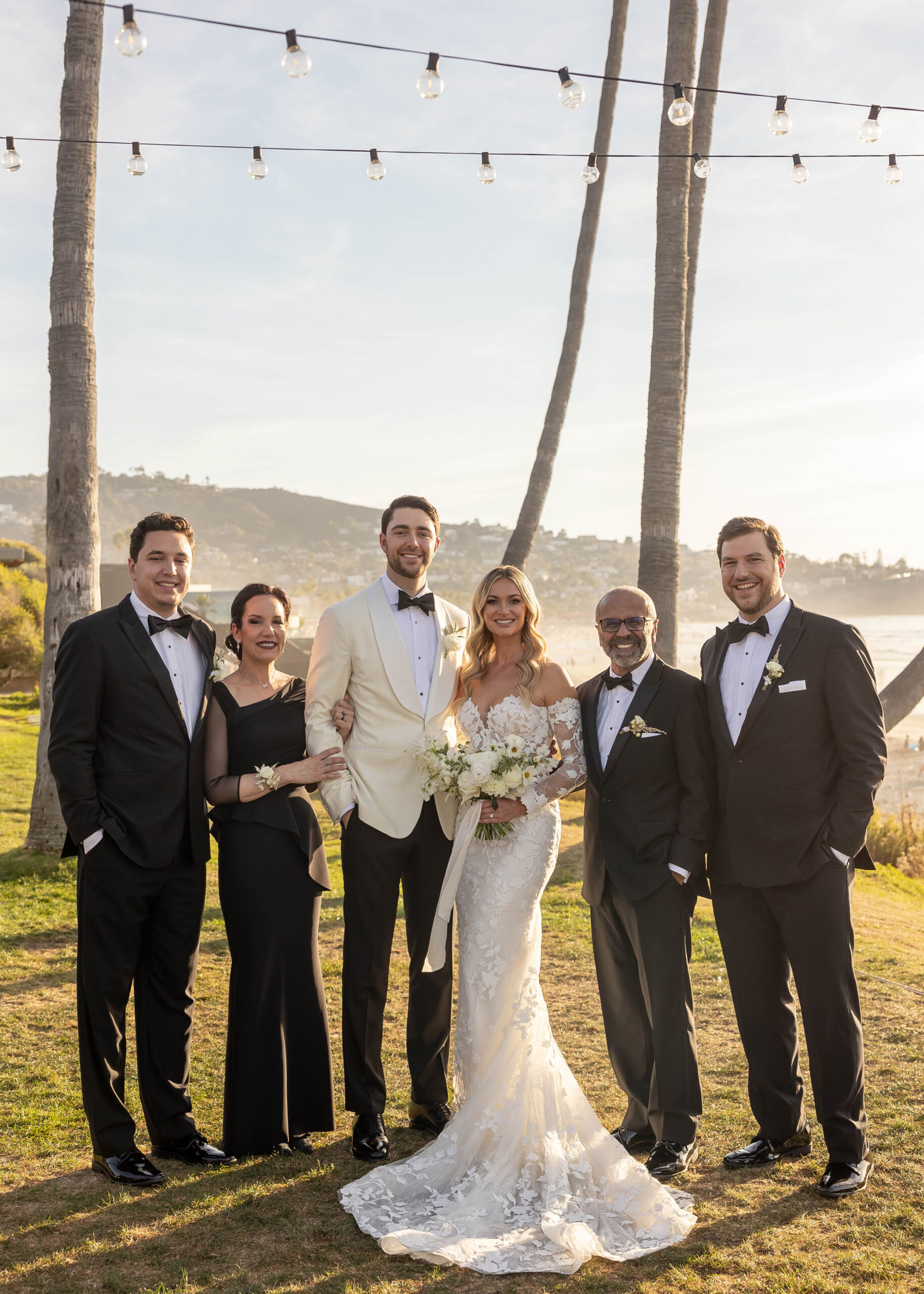 Modern wedding portraits with ocean backdrop and classic florals