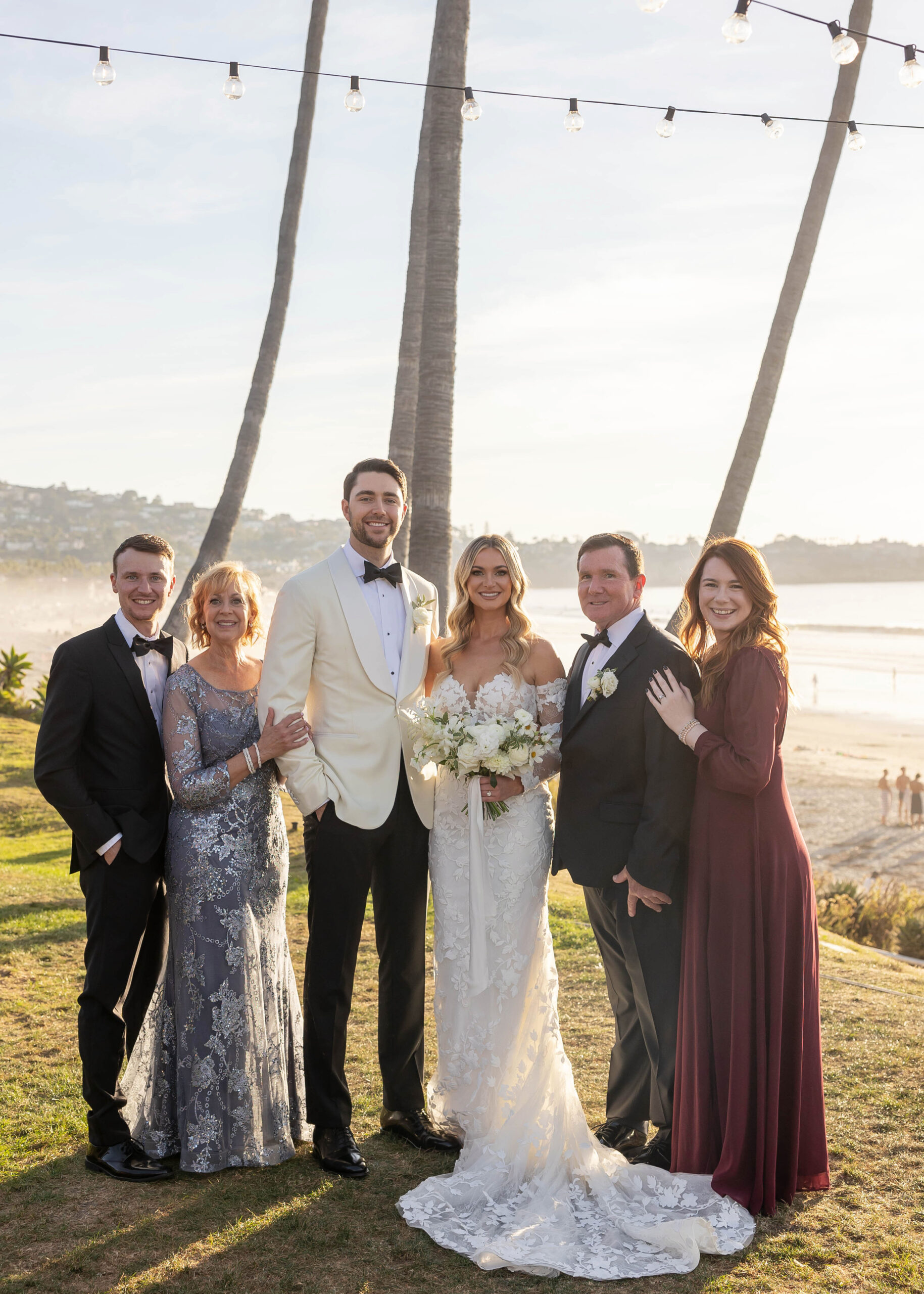 Modern wedding portraits with ocean backdrop and classic florals