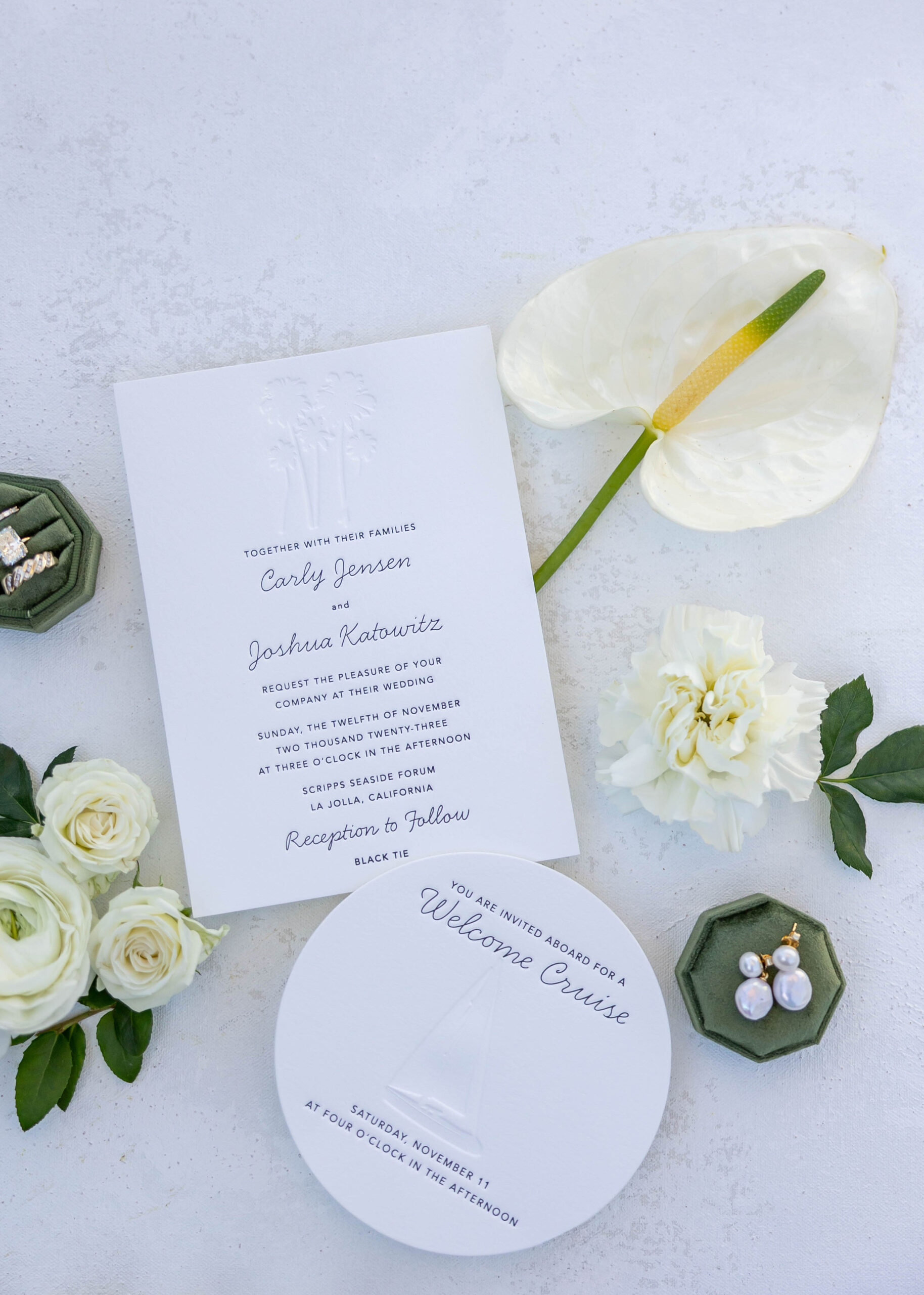 Flat lay of modern wedding invitation suite with cream accents and rings