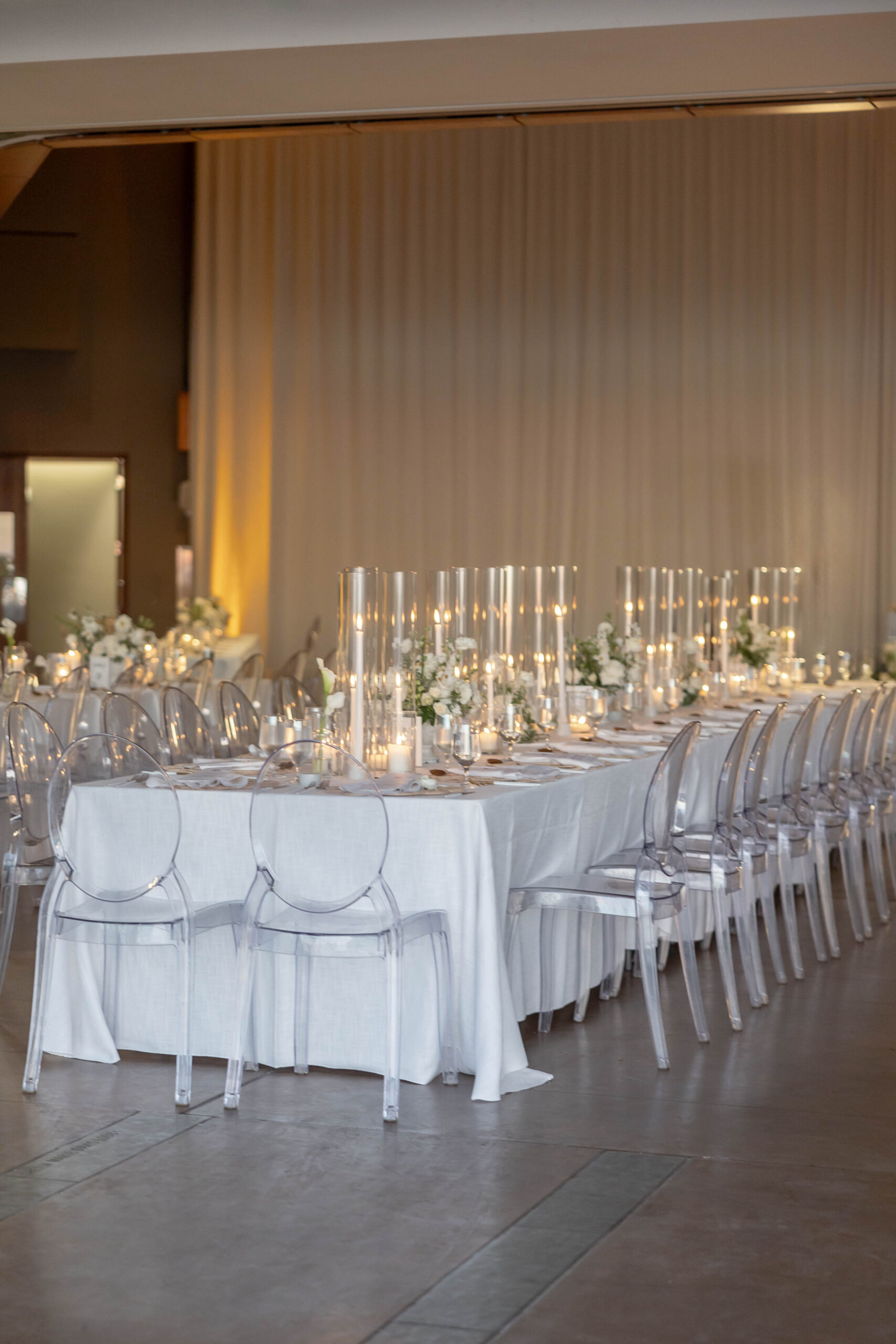 Elegant tablescape with candles, white linens, and Crown Rentals chairs