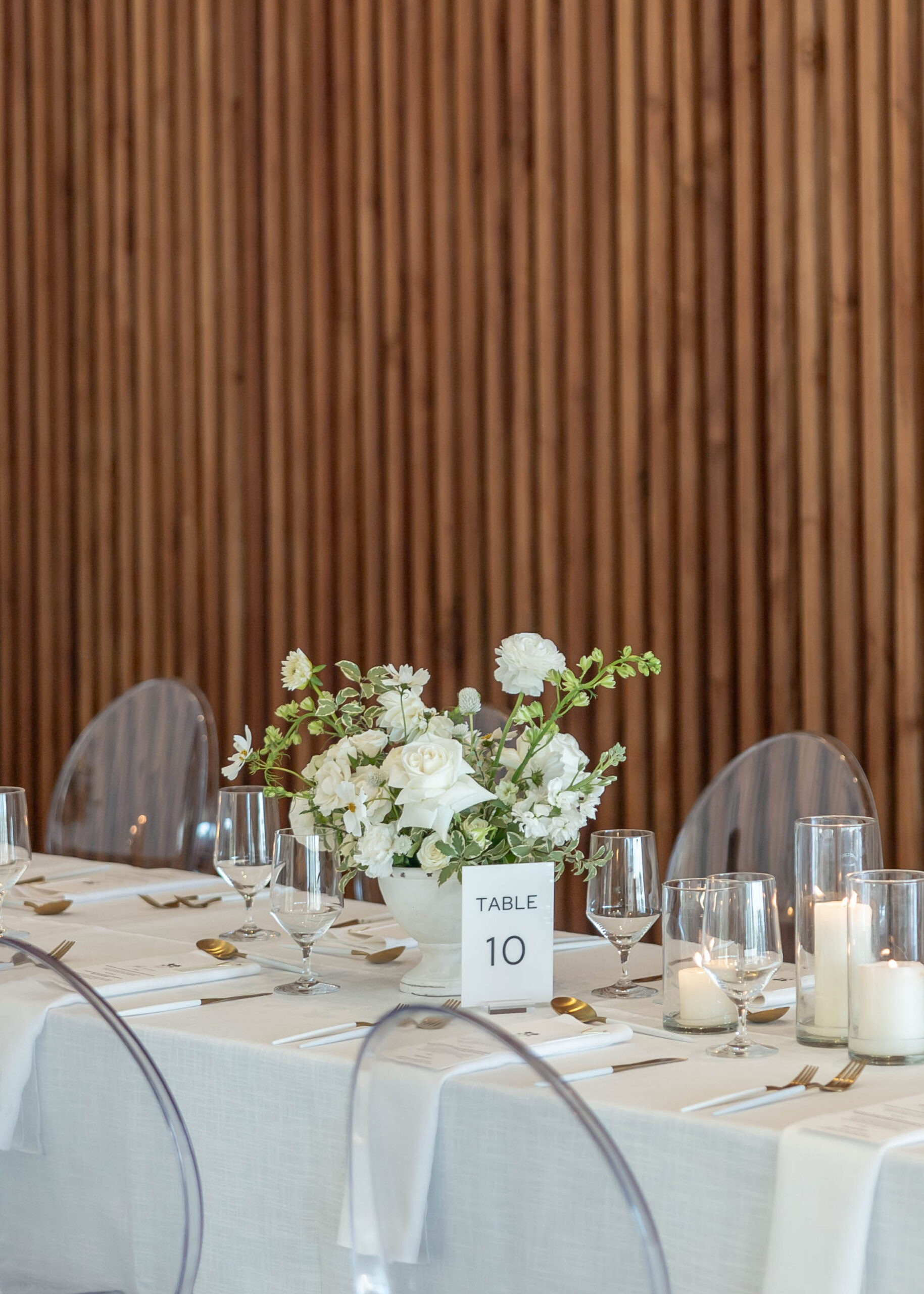 Elegant tablescape with candles, white linens, and Crown Rentals chairs