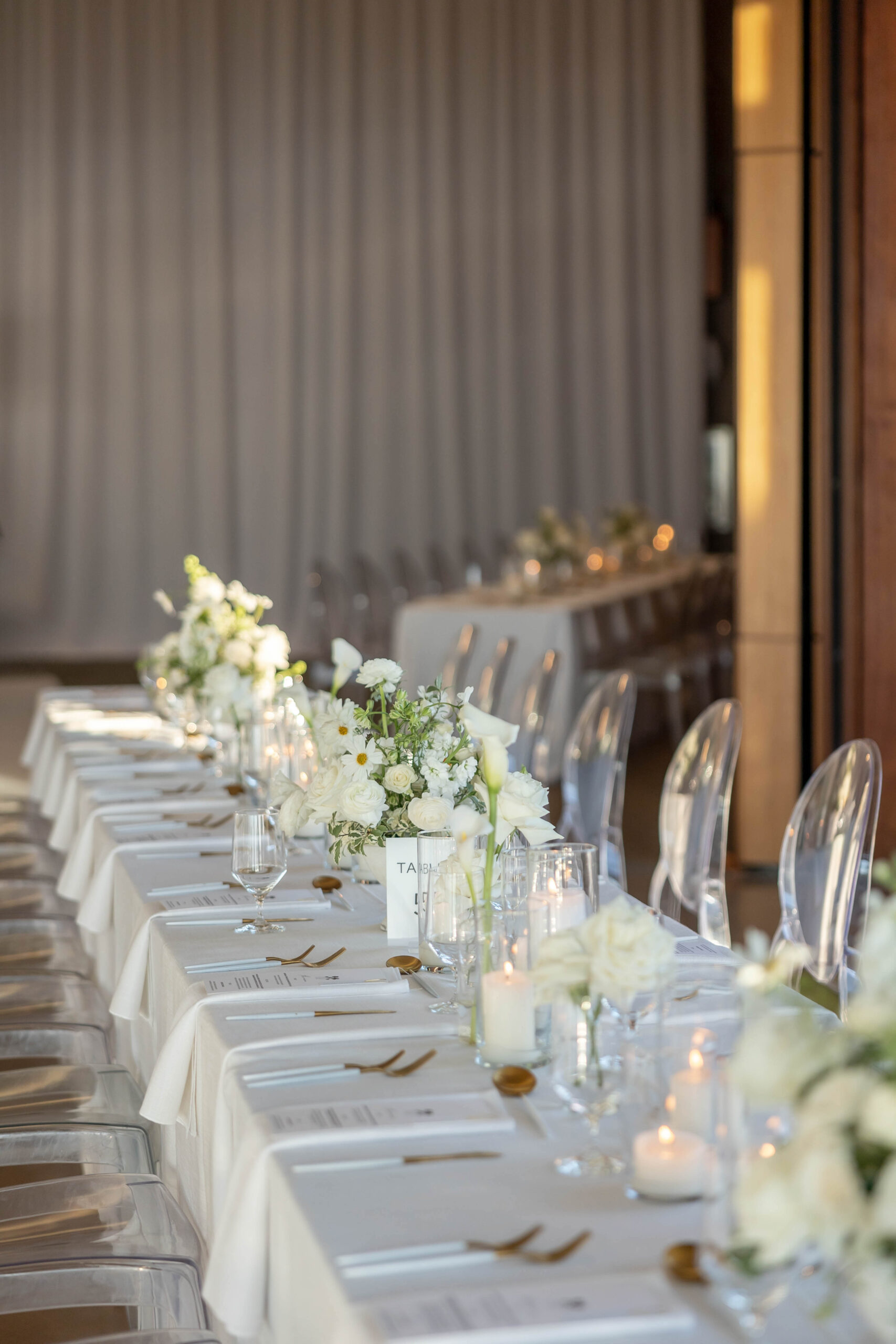 Elegant tablescape with candles, white linens, and Crown Rentals chairs